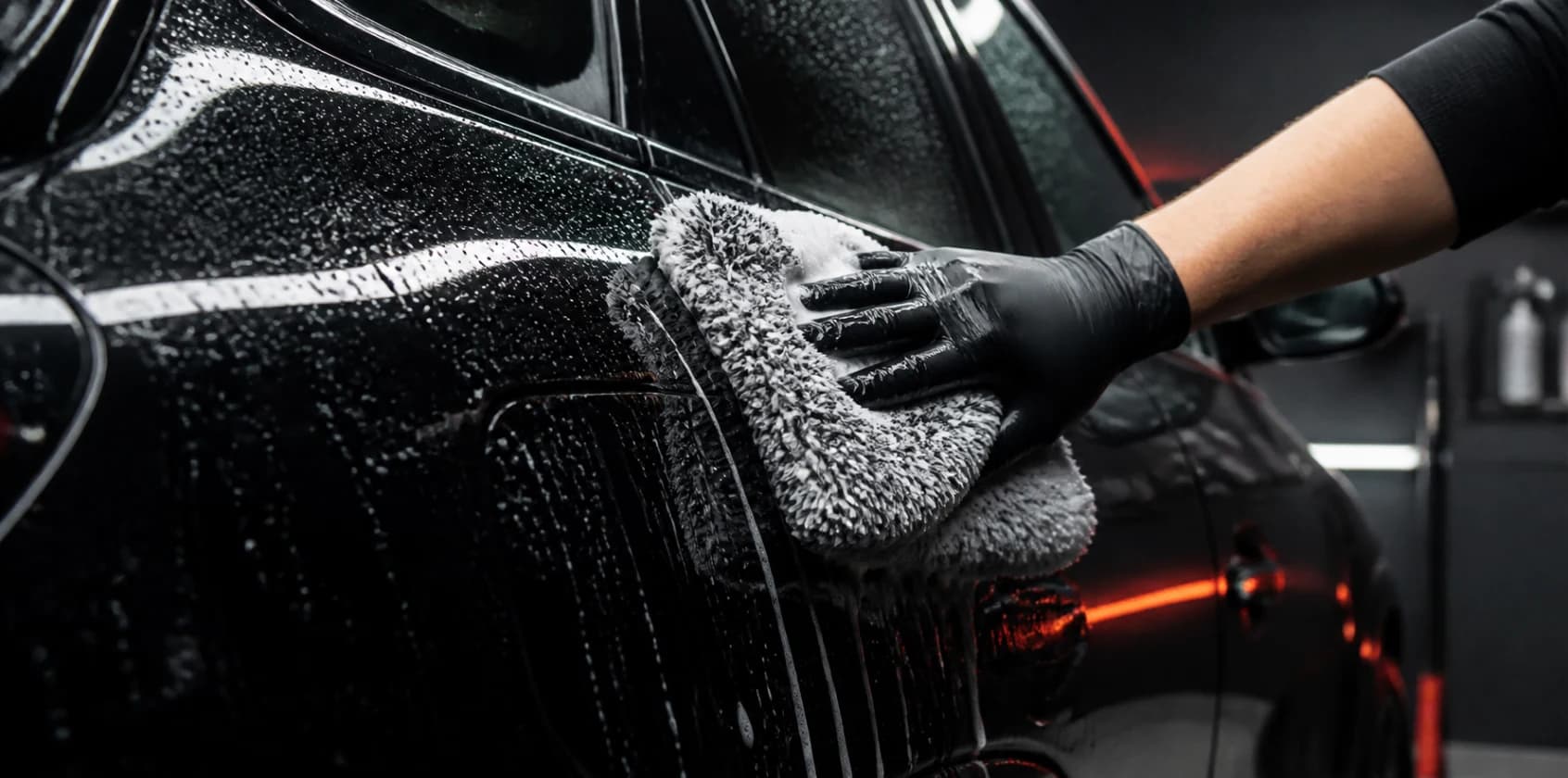 Schonende Handwäsche eines schwarzen Fahrzeugs